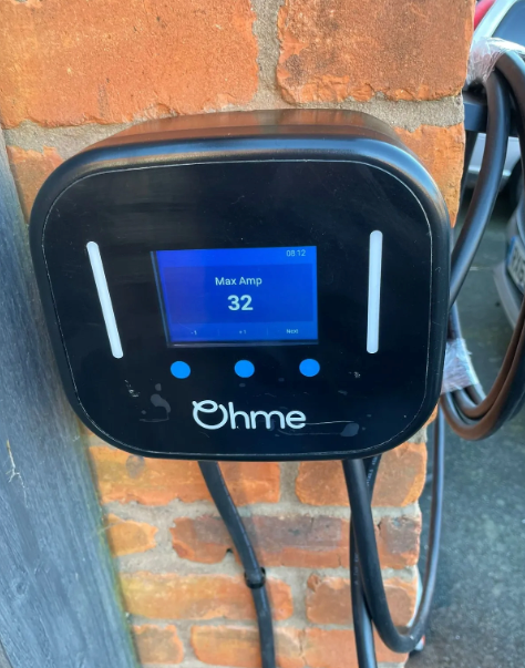 A ohme device is plugged into a brick wall