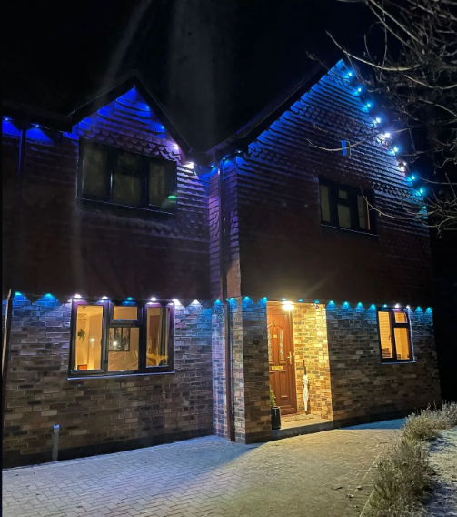 A brick house is lit up with blue lights at night