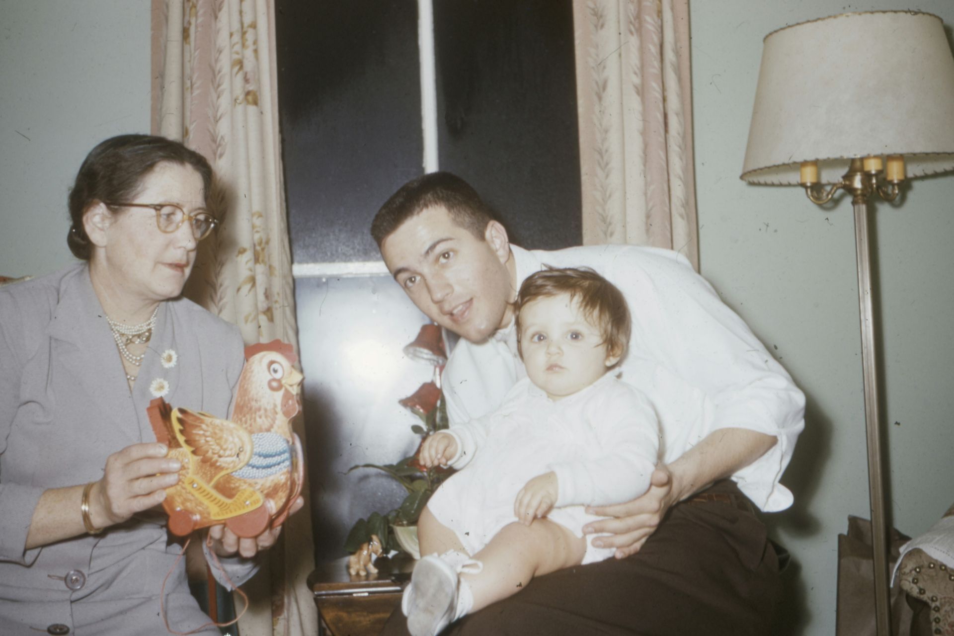 A man is holding a baby and a woman is holding a doll