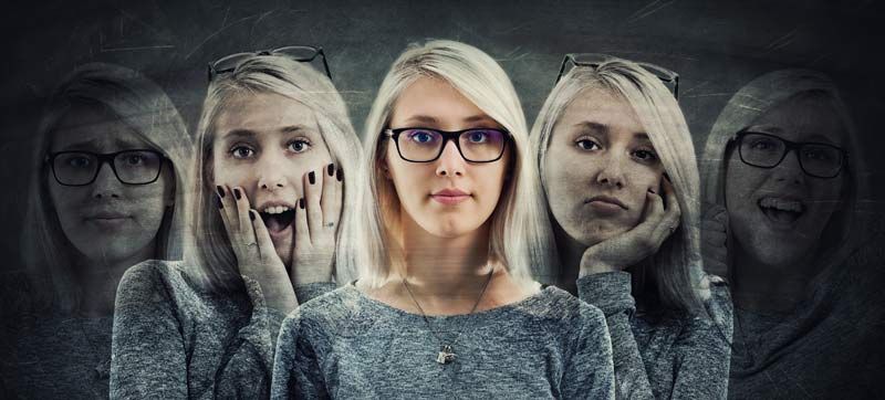 A woman wearing glasses has many different faces on her face representing Emotional Release How Emot
