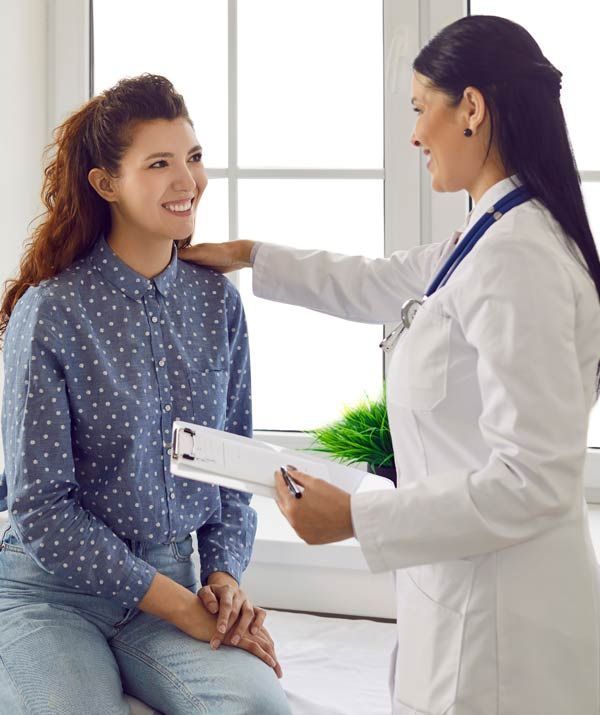A doctor is talking to a patient who is sitting in front of a window discussing Natural Remedies for PMDD at the Healing Arts NYC Health and Wellness Center in Manhattan NY 10017 and Connecticut