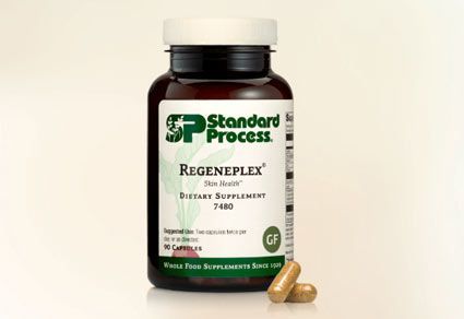 Bottle of Standard Process Regeneplex dietary supplement with two capsules in front.