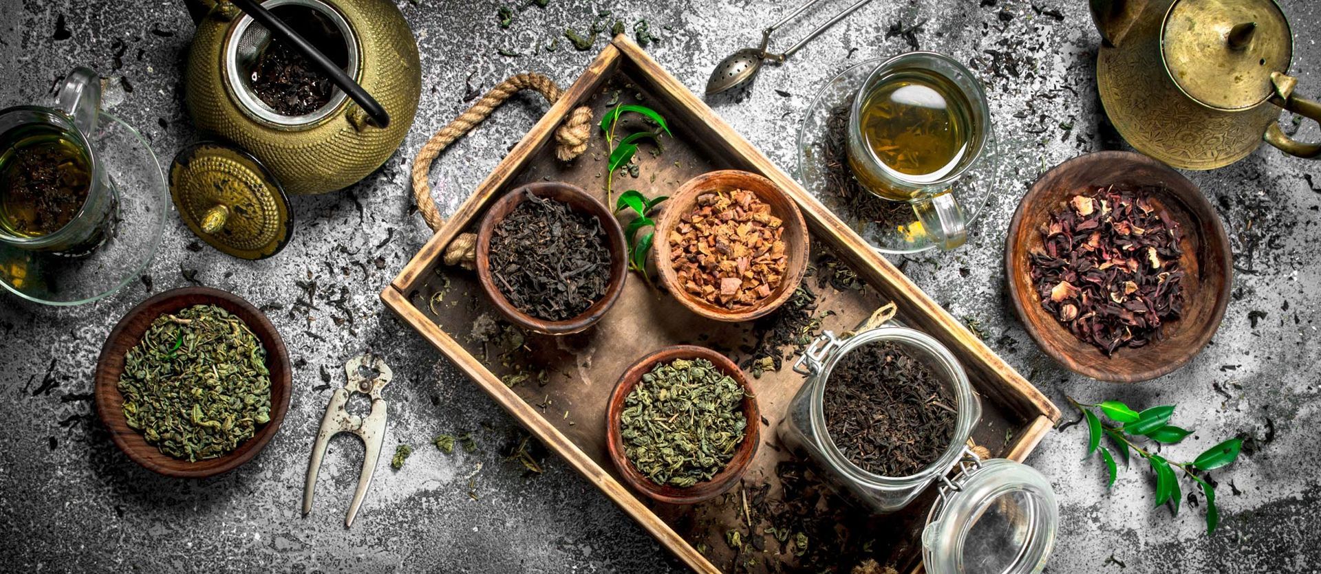 There are many different types of tea in bowls on a wooden tray. Discover the Health Benefits of Tea