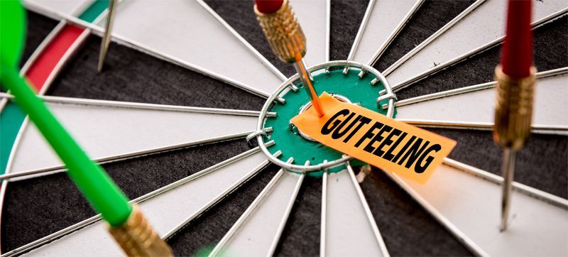 Dartboard with darts near the center where a label reads 