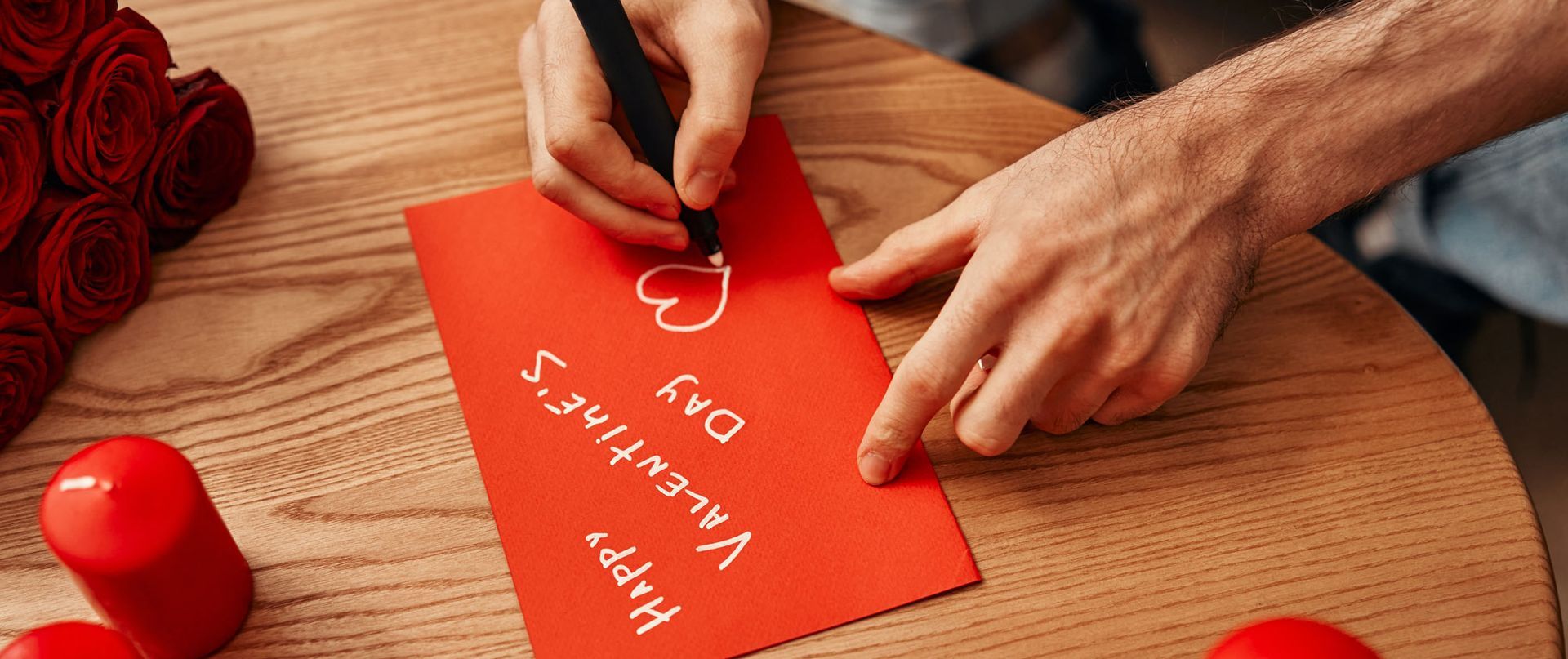 A man is writing a valentine 's day card on a wooden table. A Valentine's Gift Poem for the Healing 