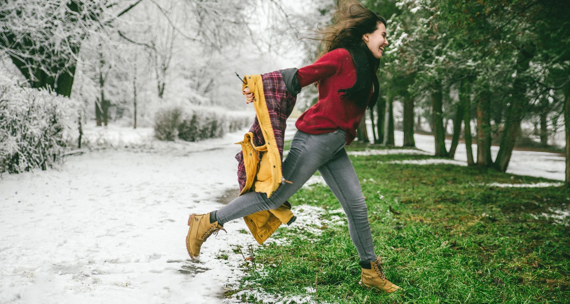 A woman is running in the snow in a park. How Your Body Adapts from the Winter and Spring Seasons