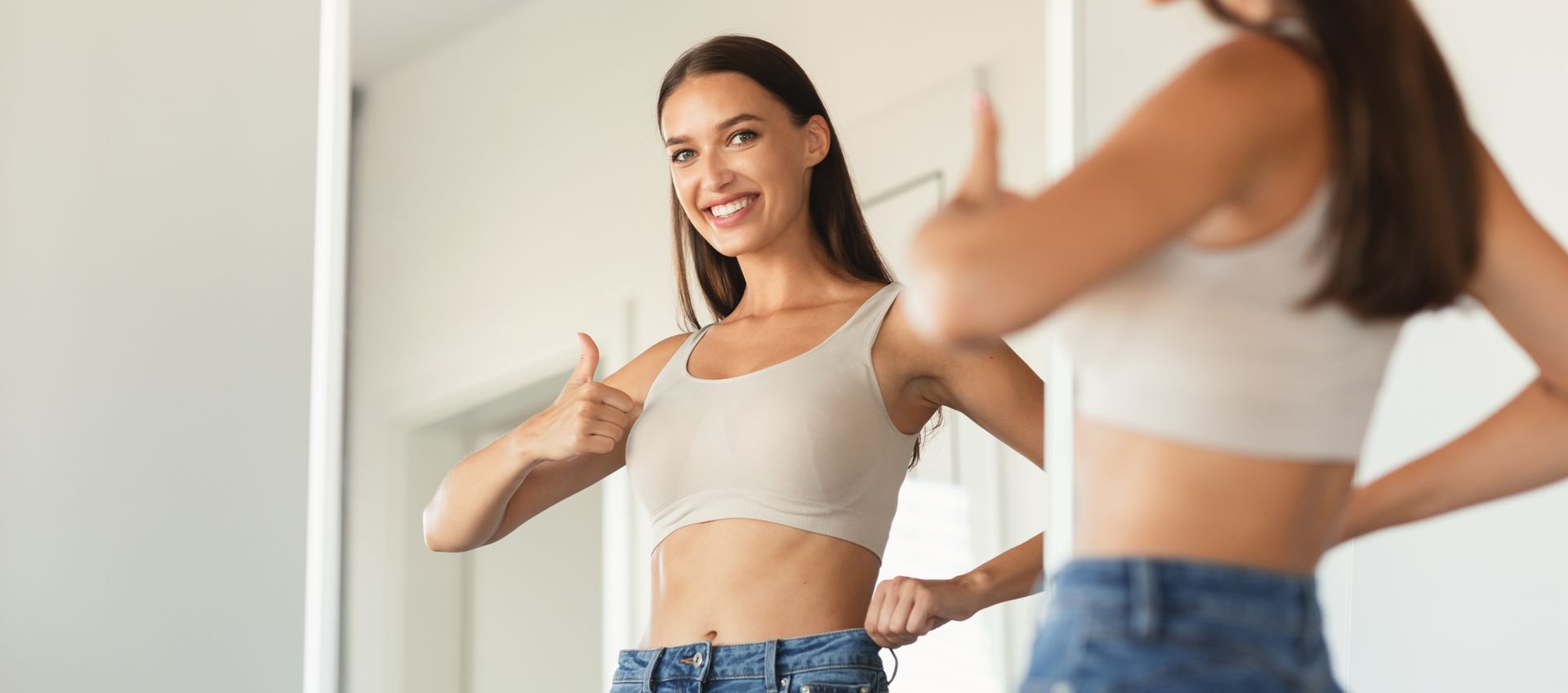 A woman is standing in front of a mirror, thumbs up. After reading What You Can Do in the Spring