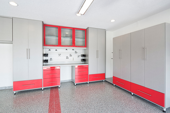 A garage with red and gray cabinets and drawers