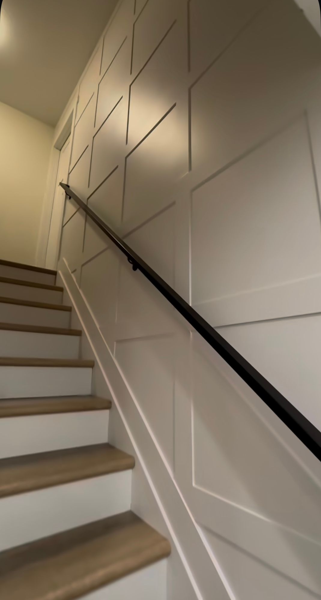 A staircase with wooden steps and a black railing