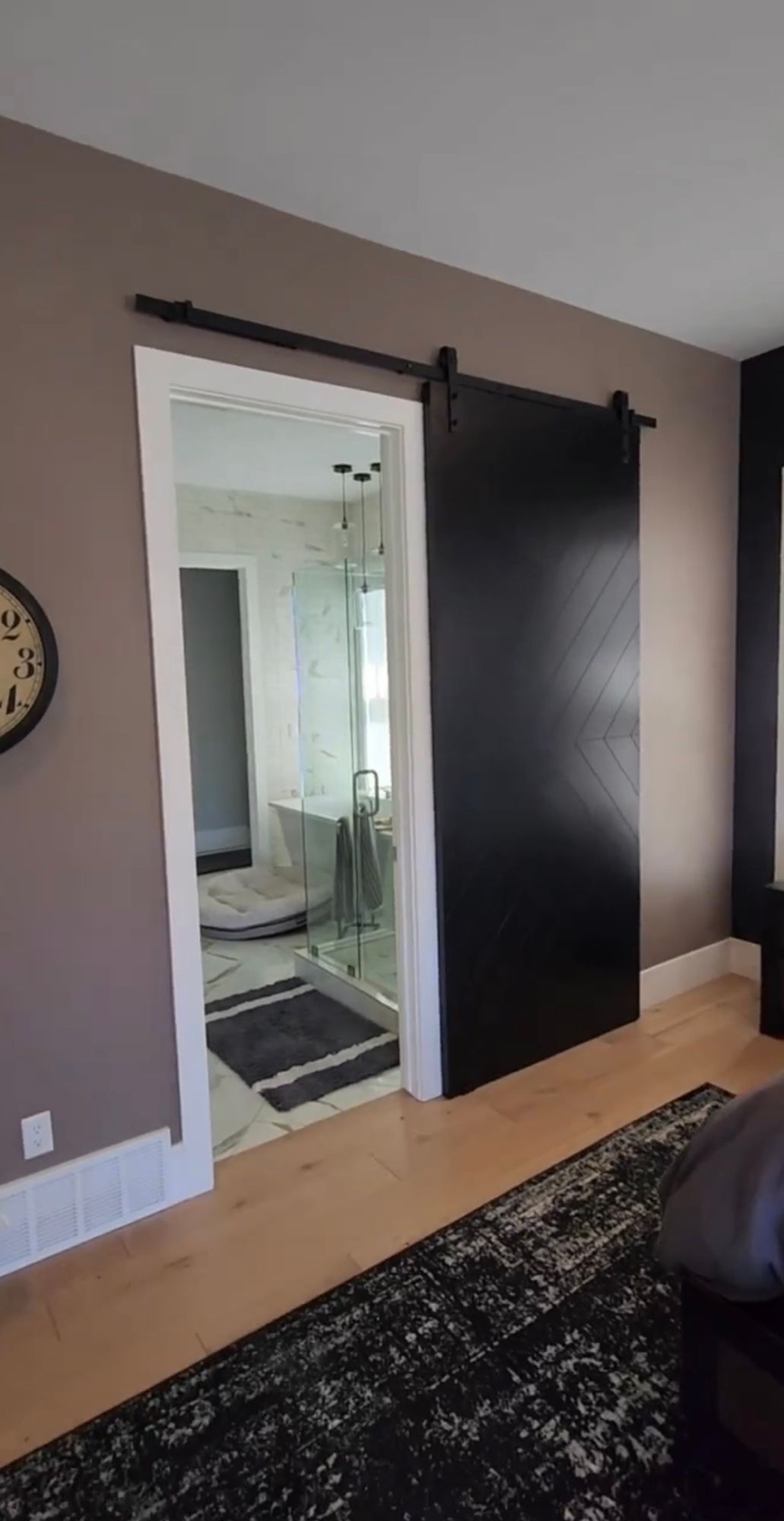 A living room with a sliding barn door leading to a bathroom.