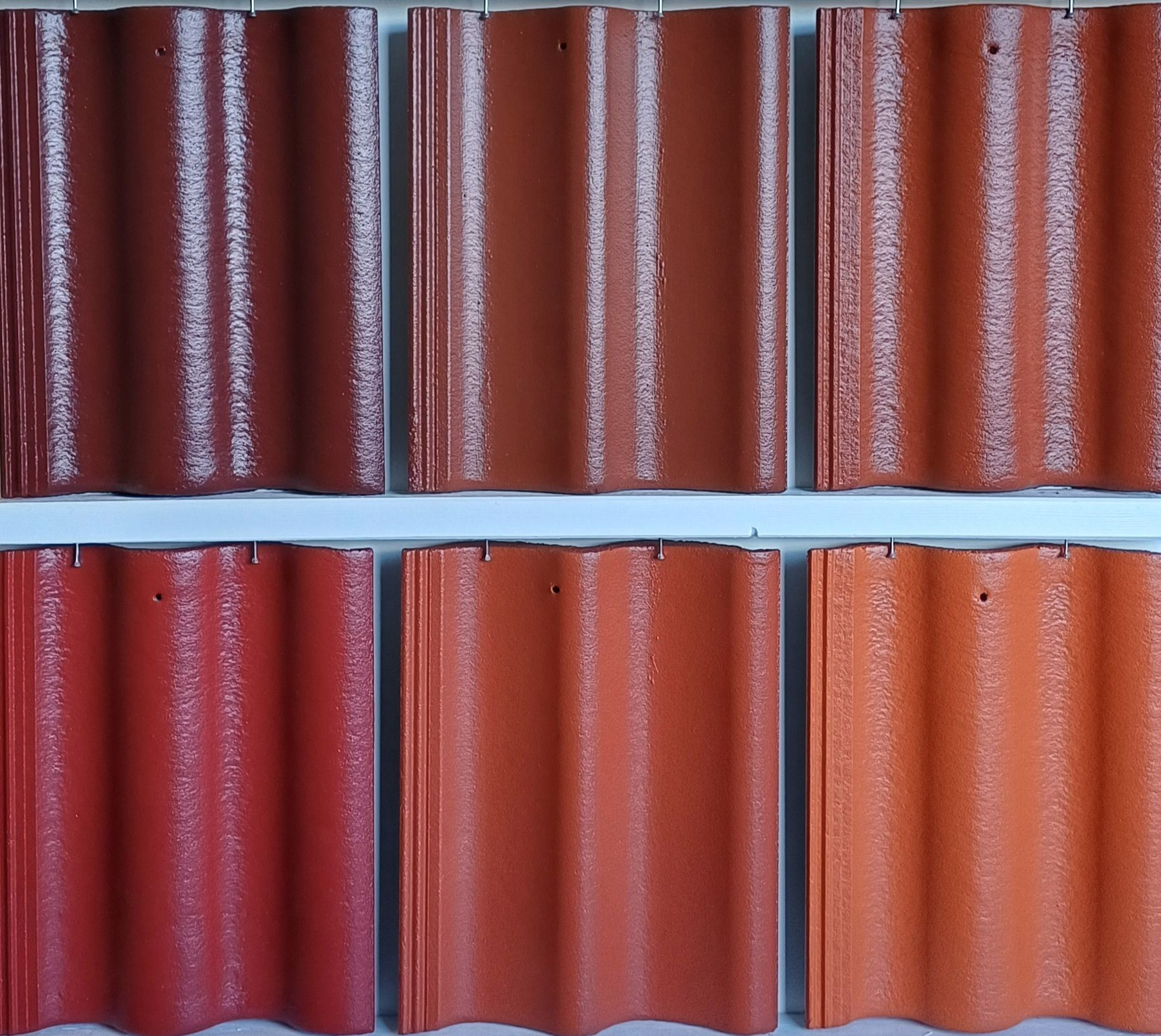 Close-up of a tile roof covered in debris and moss. A gutter is visible on the right. Green trees in the background.