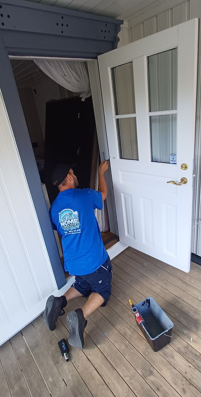 A roof with brown tiles and a chimney, next to a grassy hill and dirt path.