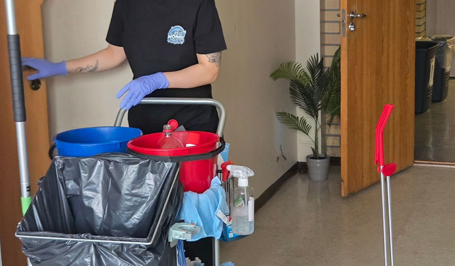 Drone in flight, front view. White and black body with four propellers. Blurred background.
