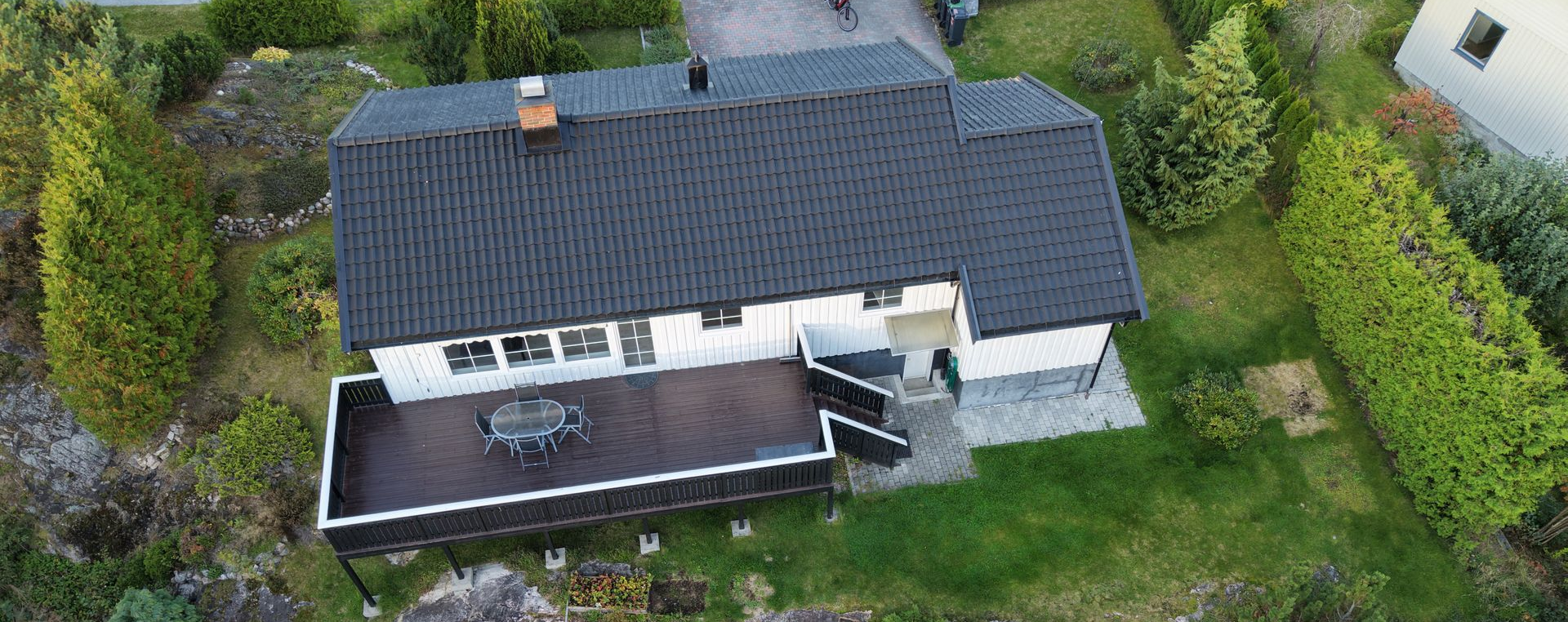 Two side-by-side images of a roof. One is clean and the other is covered in moss. Blue sky on the left.