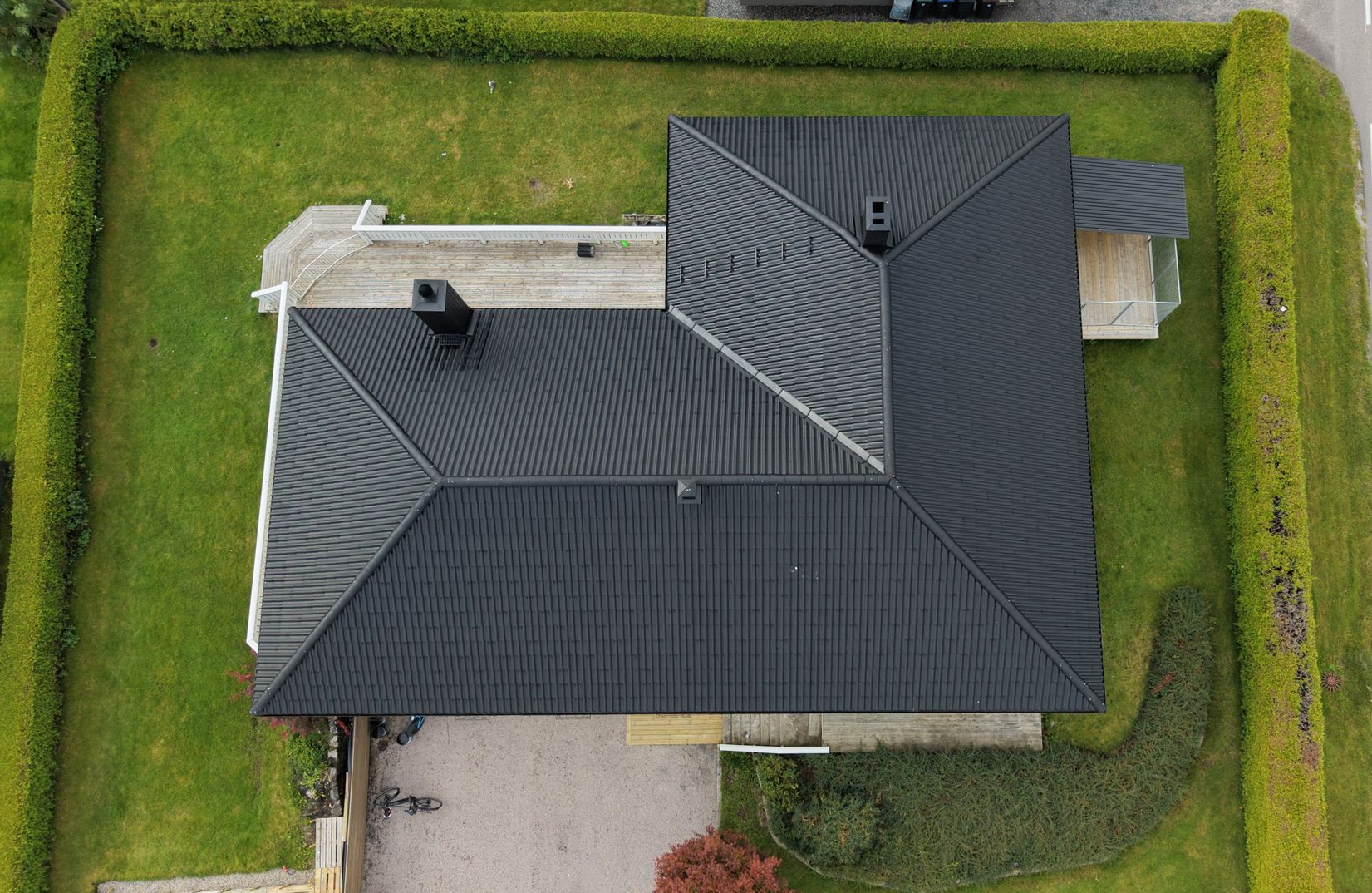 Close-up of a red tile roof with a metal rail running along the top.