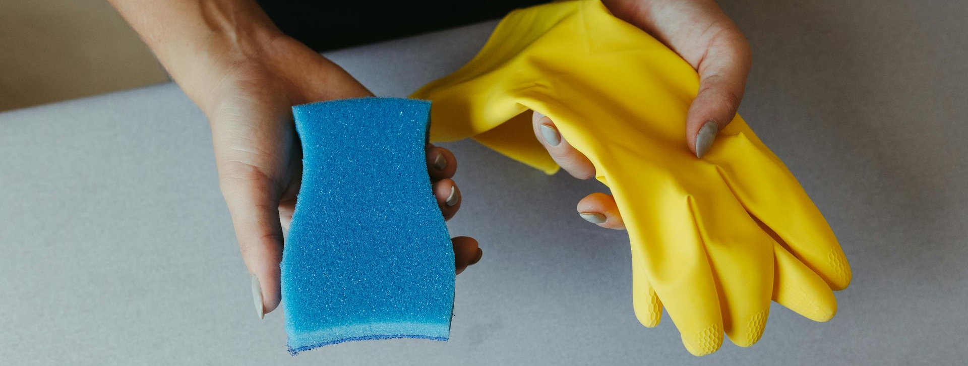 Gray corrugated roof with sunlight creating long shadows, showing some damaged tiles near a small skylight.