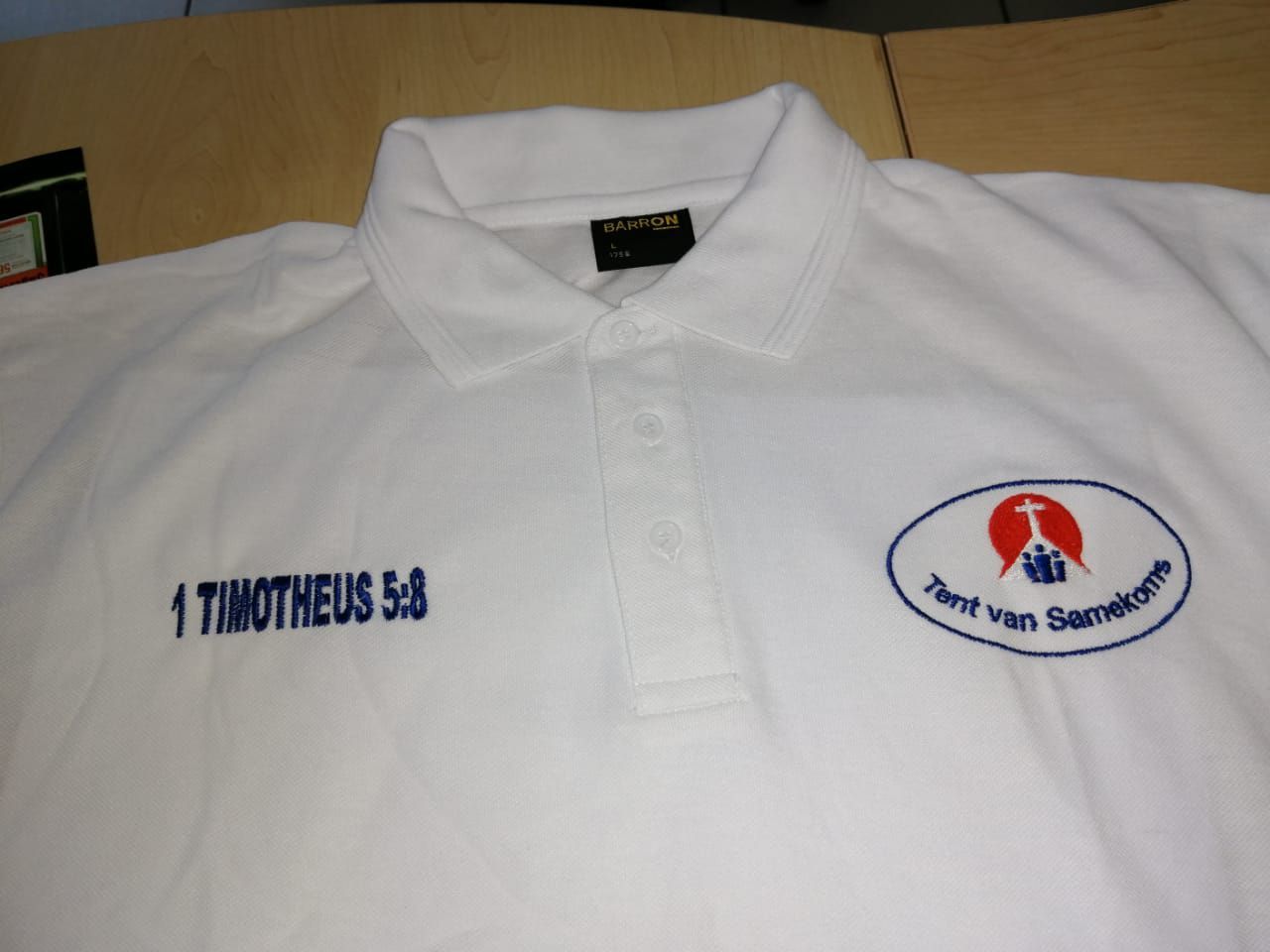 A white polo shirt with the name timotheus embroidered on it