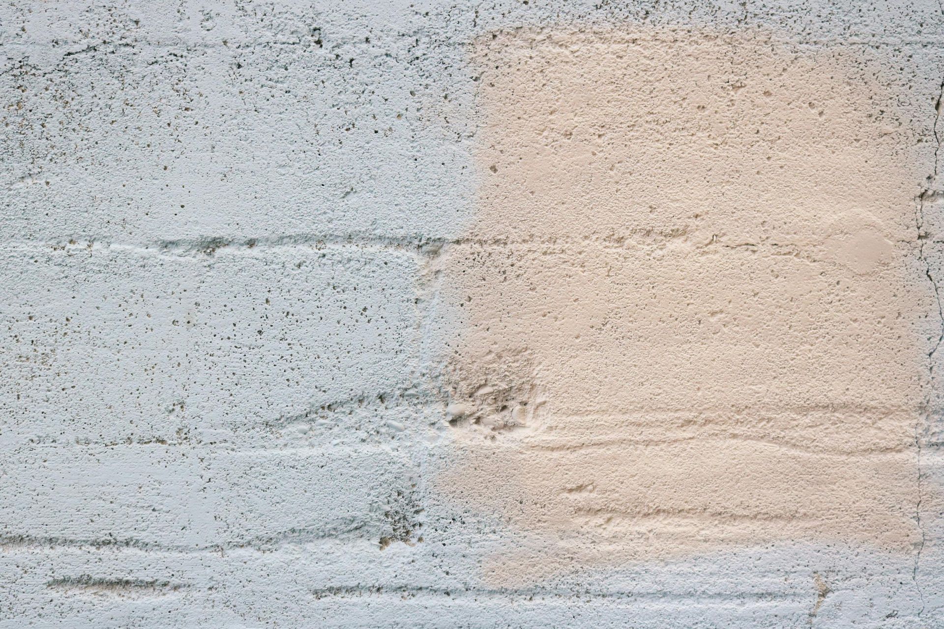 White and tan painted brick wall texture with visible horizontal lines.