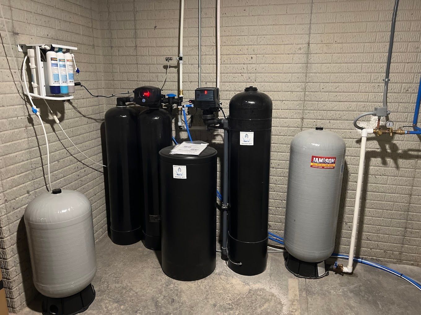 Three tanks are lined up next to each other in front of a blue tank.