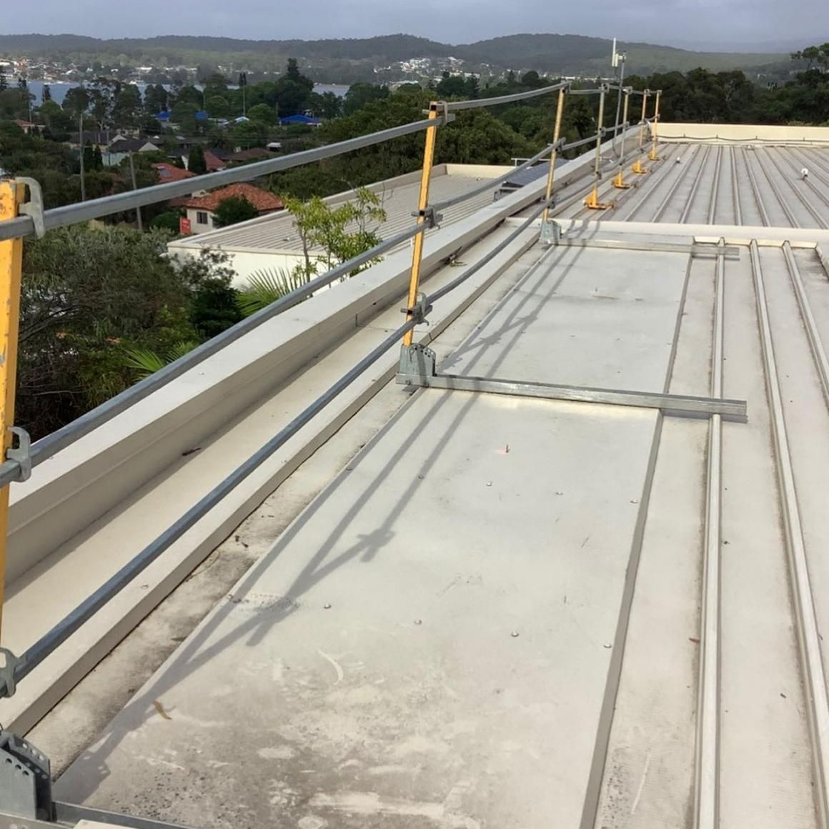 A Roof with A Yellow Railing on It — Site Safety NSW in Lake Macquarie, NSW