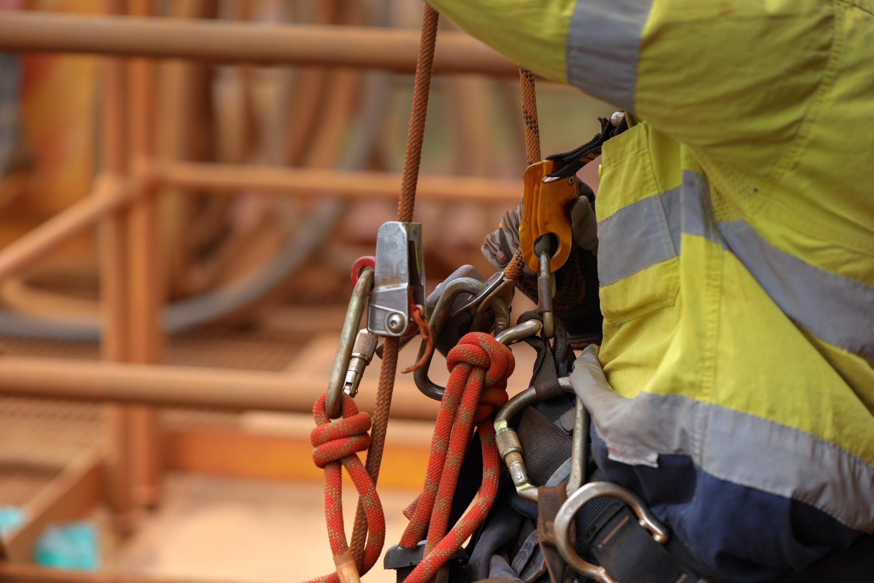 A Worker Using Climbing Ropes and Carabiners on A Metal Structure — Site Safety NSW in Mid North Coast, NSW