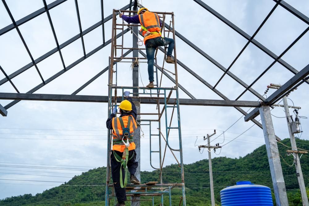 Two Construction Workers Are Working on A Metal Structure on A Scaffolding — Site Safety NSW in Mid North Coast, NSW