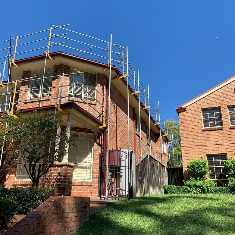 A Brick House with Scaffolding on The Side of It — Site Safety NSW in Hunter Valley, NSW
