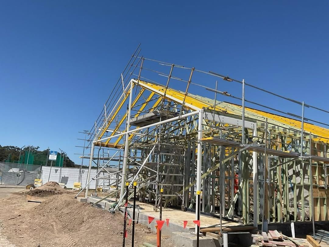 A Building Under Construction with Scaffolding and A Blue Sky in The Background — Site Safety NSW in Lake Macquarie, NSW