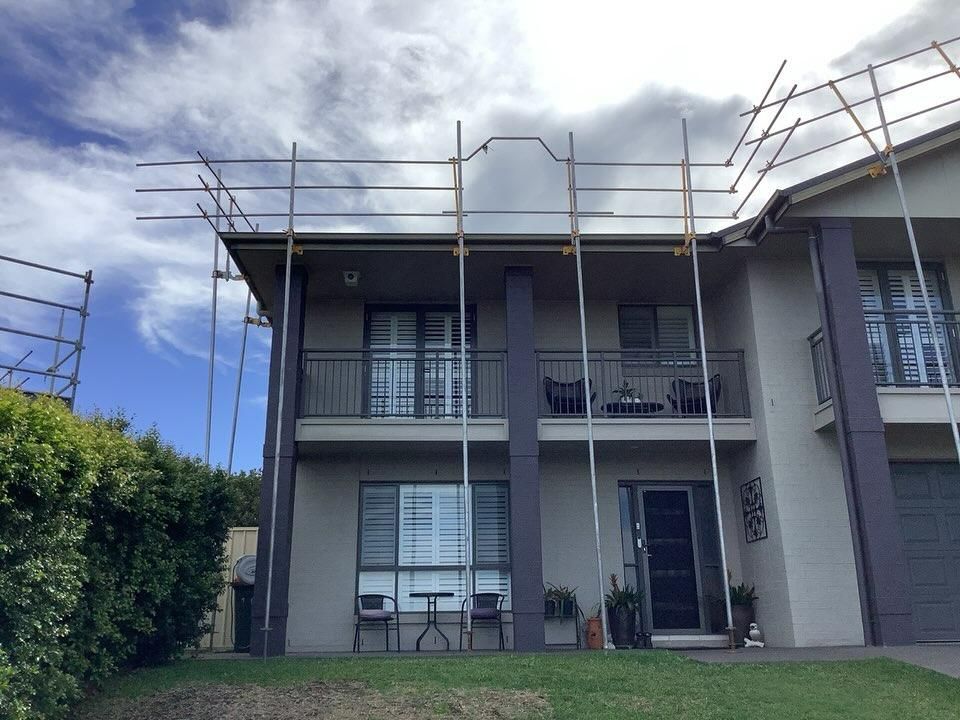 A House with Scaffolding on The Side of It — Site Safety NSW in Lake Macquarie, NSW