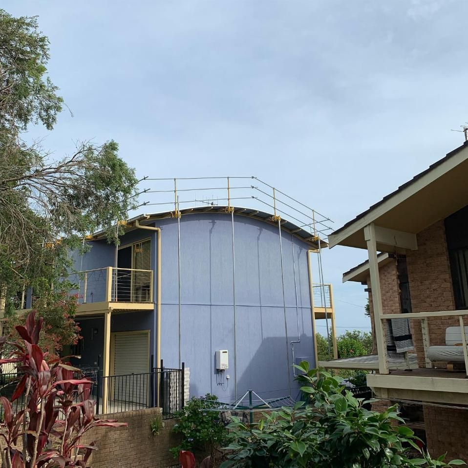 A Blue Building with A Balcony on Top of It — Site Safety Nsw in Hunter Valley, NSW