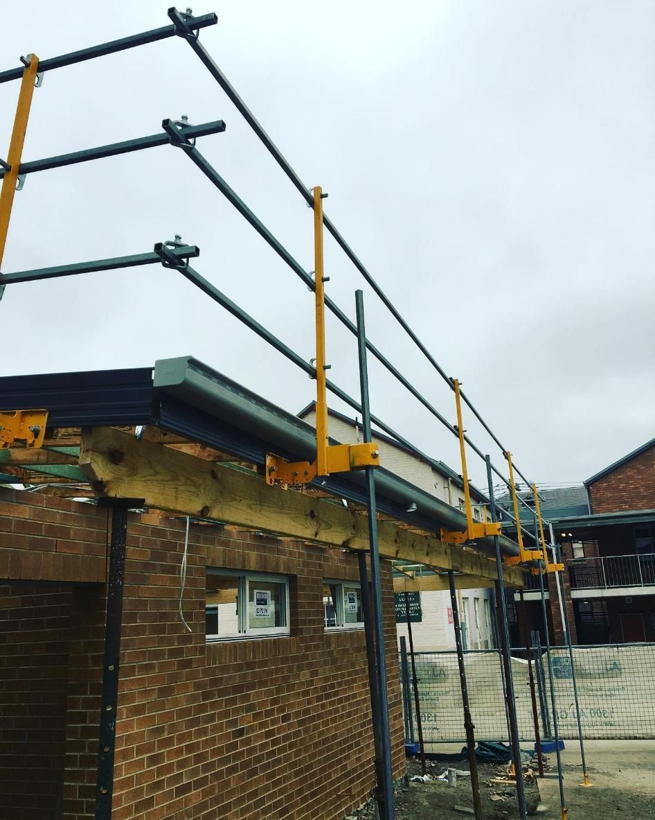 A Brick Building with Scaffolding on The Side of It — Site Safety NSW in Port Macquarie, NSW