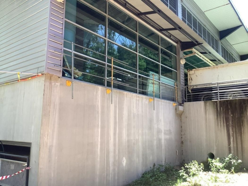 A Building with A Lot of Windows and A Bridge in The Background — Site Safety NSW in Sandgate, NSW