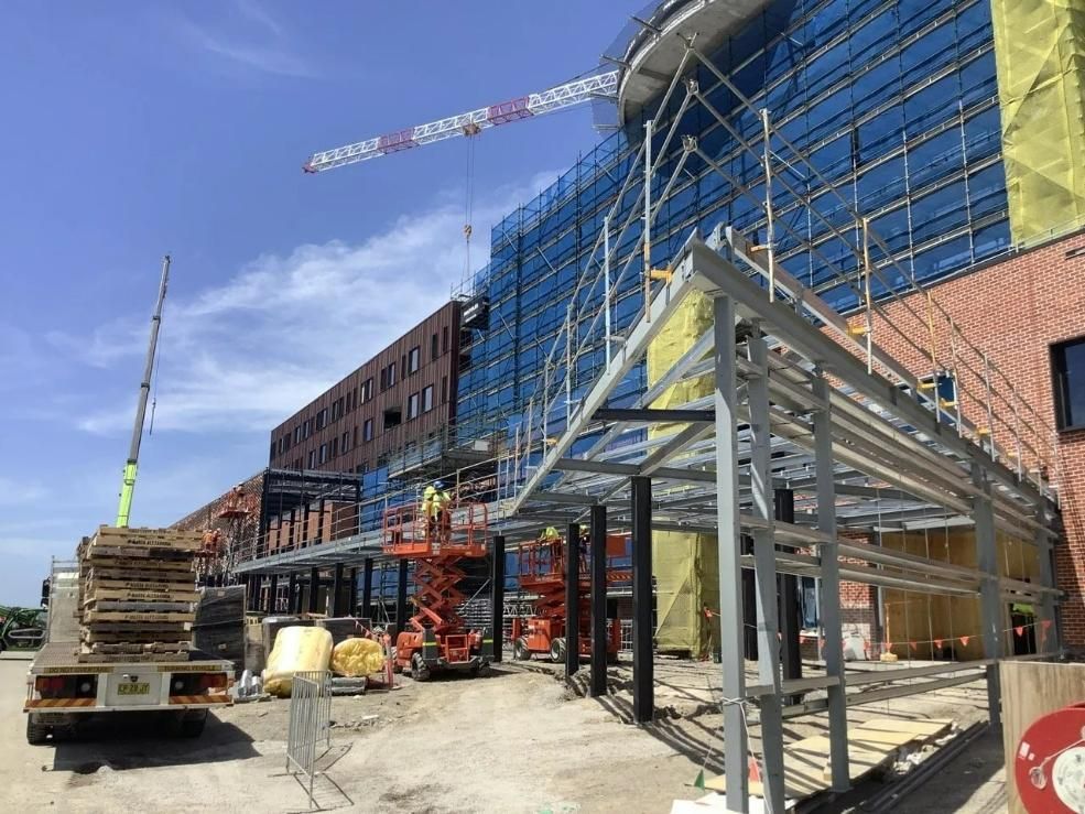 A Large Building Under Construction with A Crane in The Background — Site Safety NSW in Sandgate, NSW