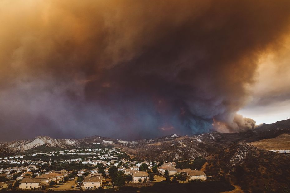 Wildfire smoke approaching residential community, highlighting the need for The Wildfire Guardian™ wildfire protection system.