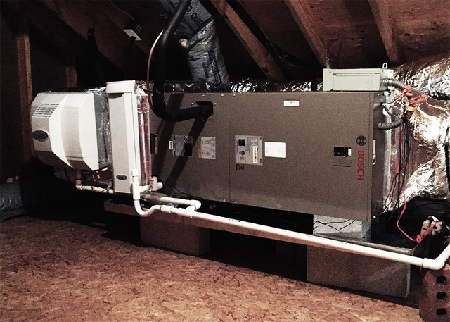 HVAC unit in an attic with ducts, pipes, and insulation.