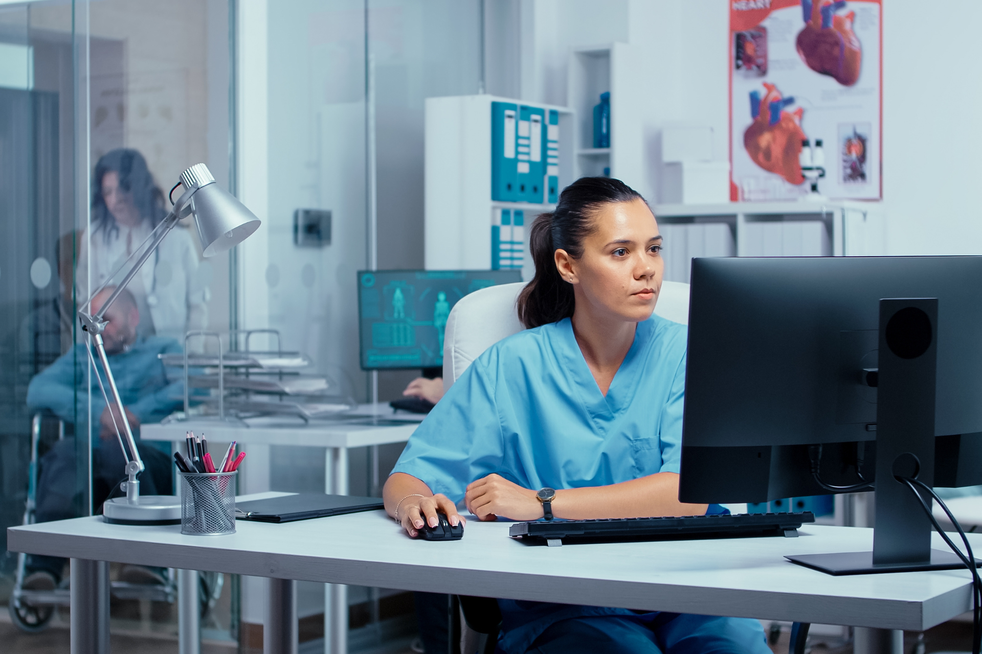 A smiling nurse uses a computer confidently, showing how the easy-to-navigate IMS EHR has replaced frustration with ease.