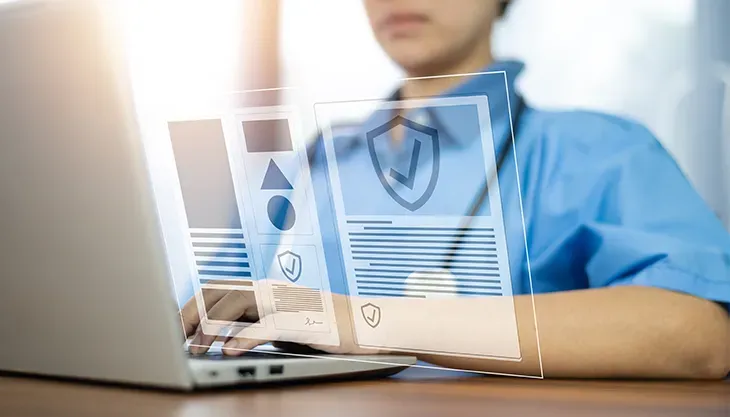 A doctor is using a laptop computer with a futuristic screen.