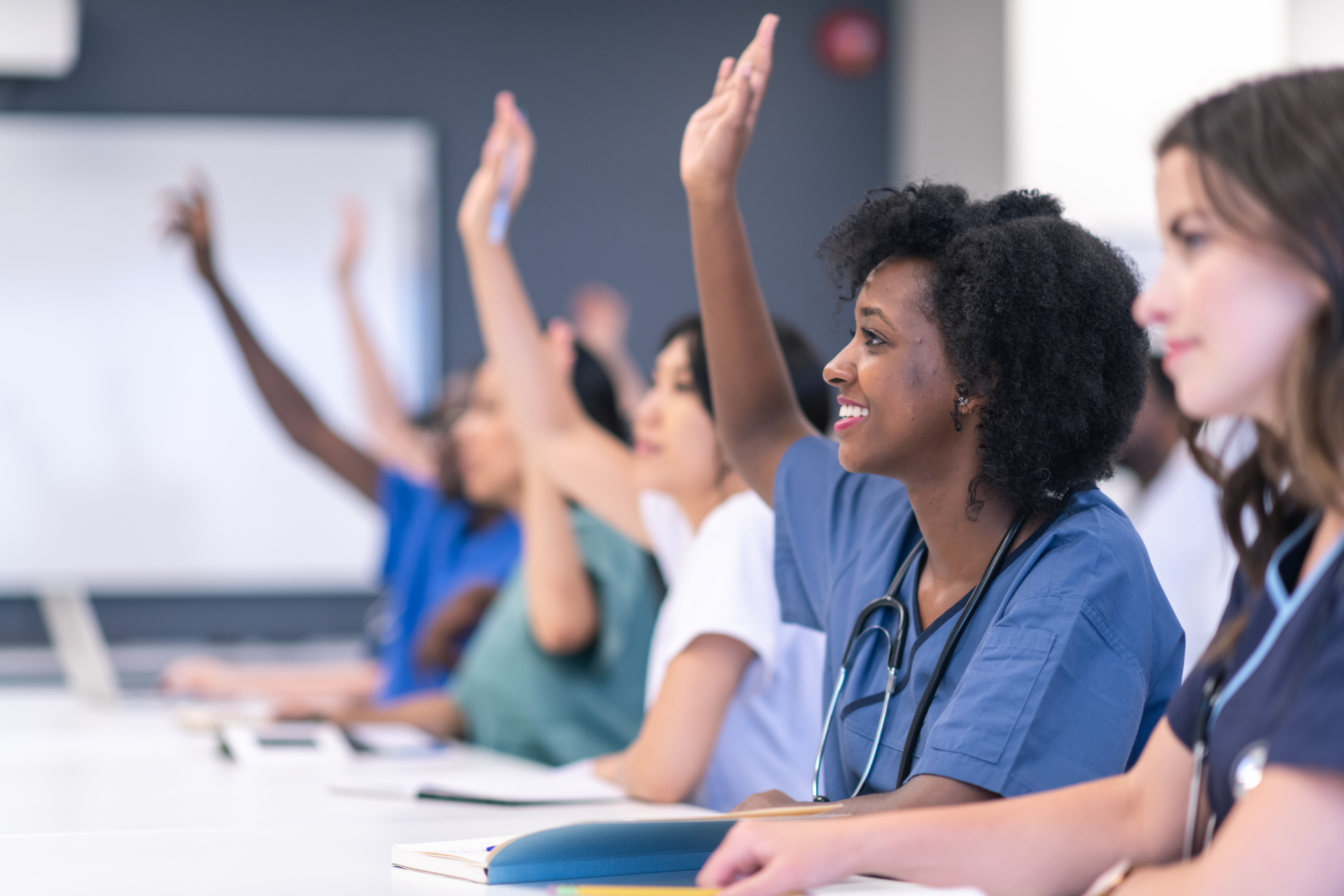 Medical office employees attend OSHA training for healthcare workers and actively participate during the training session.