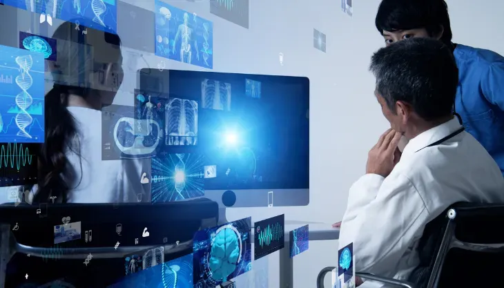 A doctor is using a laptop computer with a futuristic screen.