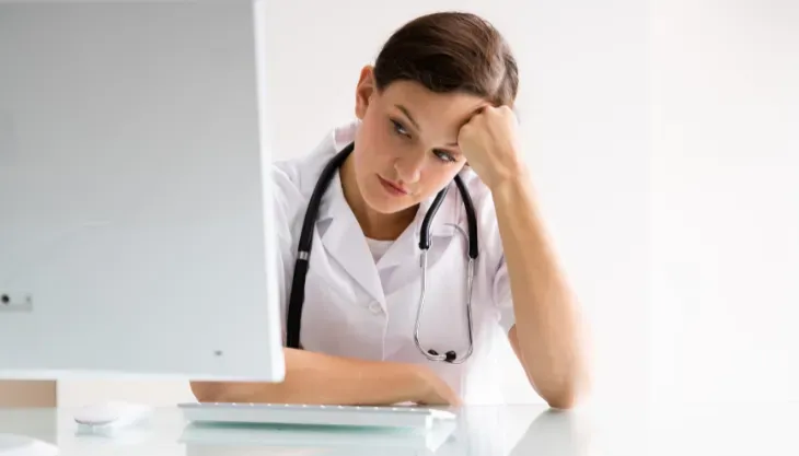 A doctor is holding a tablet in front of an ims logo