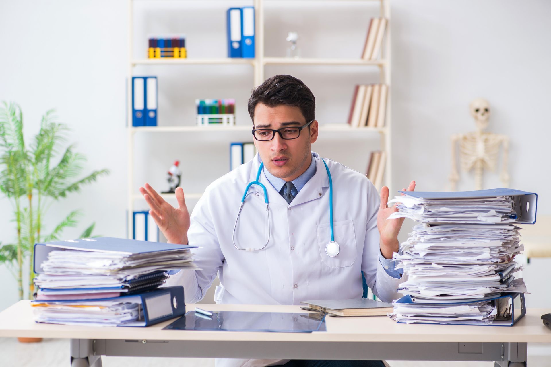 A nurse wearing a headset is sitting in front of a computer.
