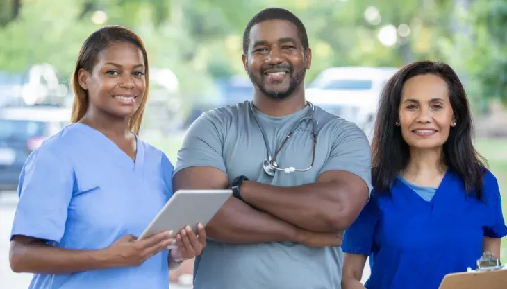 A group of nurses and a doctor are posing for a picture.