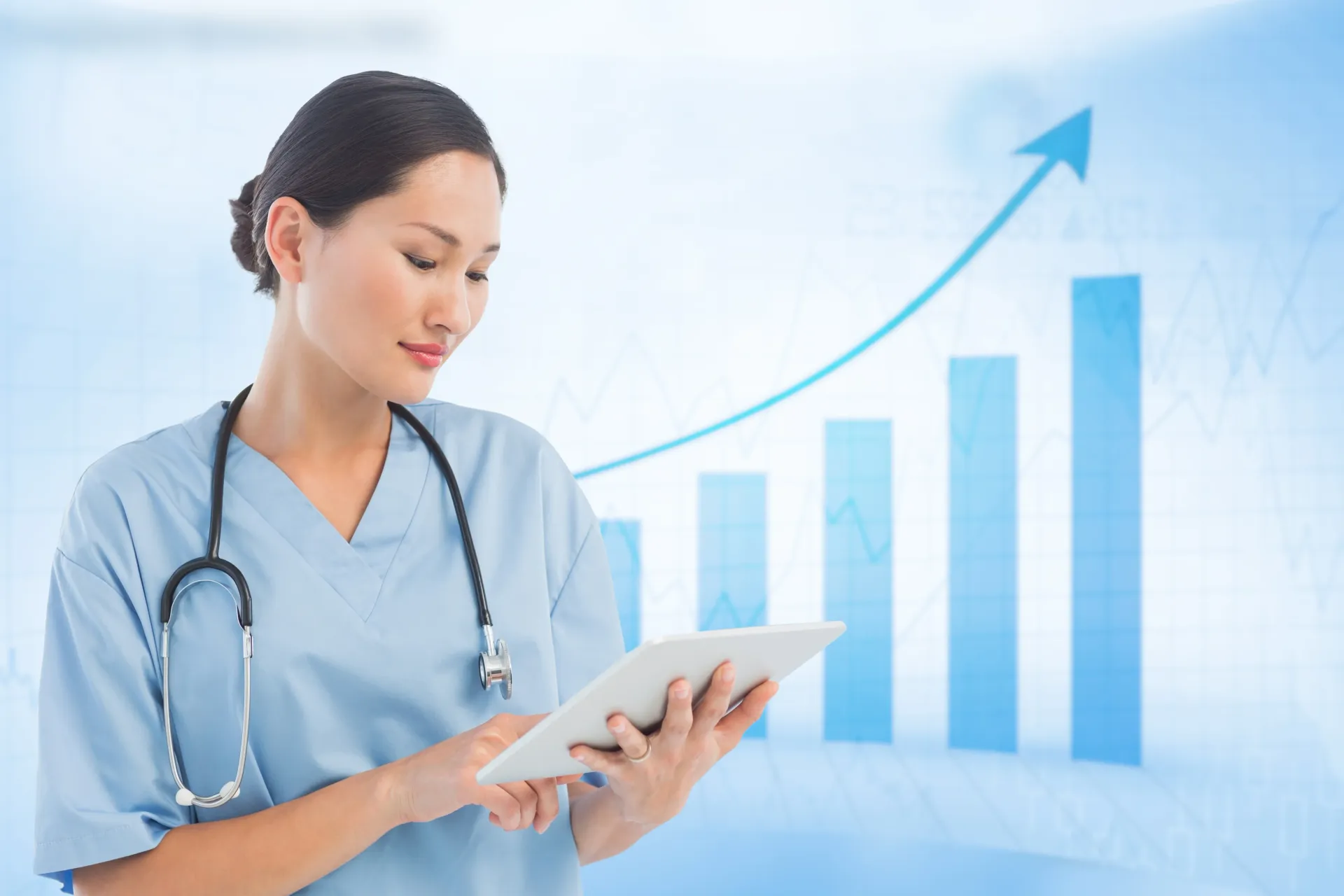 A nurse is holding a tablet in front of a graph.