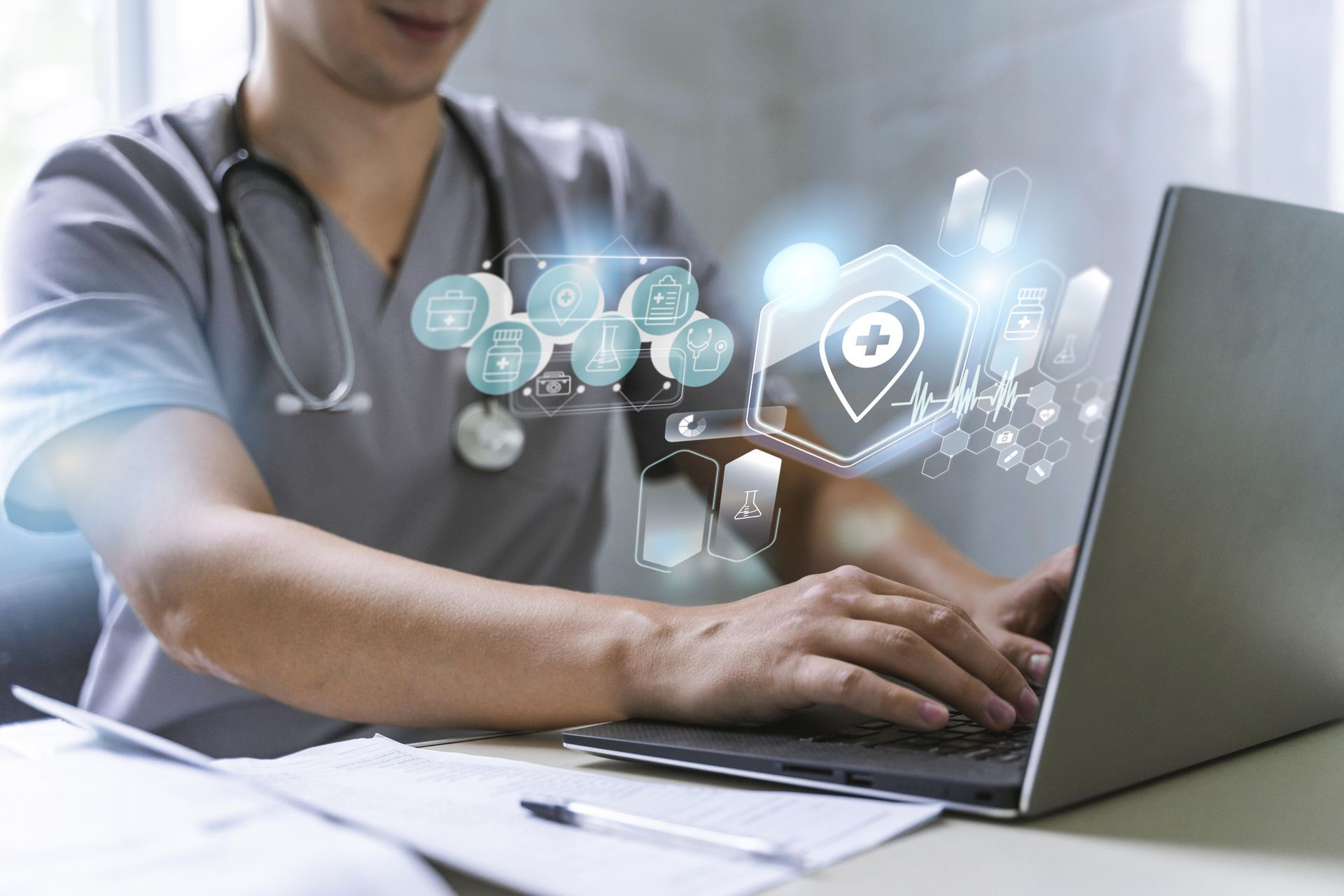 A doctor is using a laptop computer with a stethoscope around his neck.