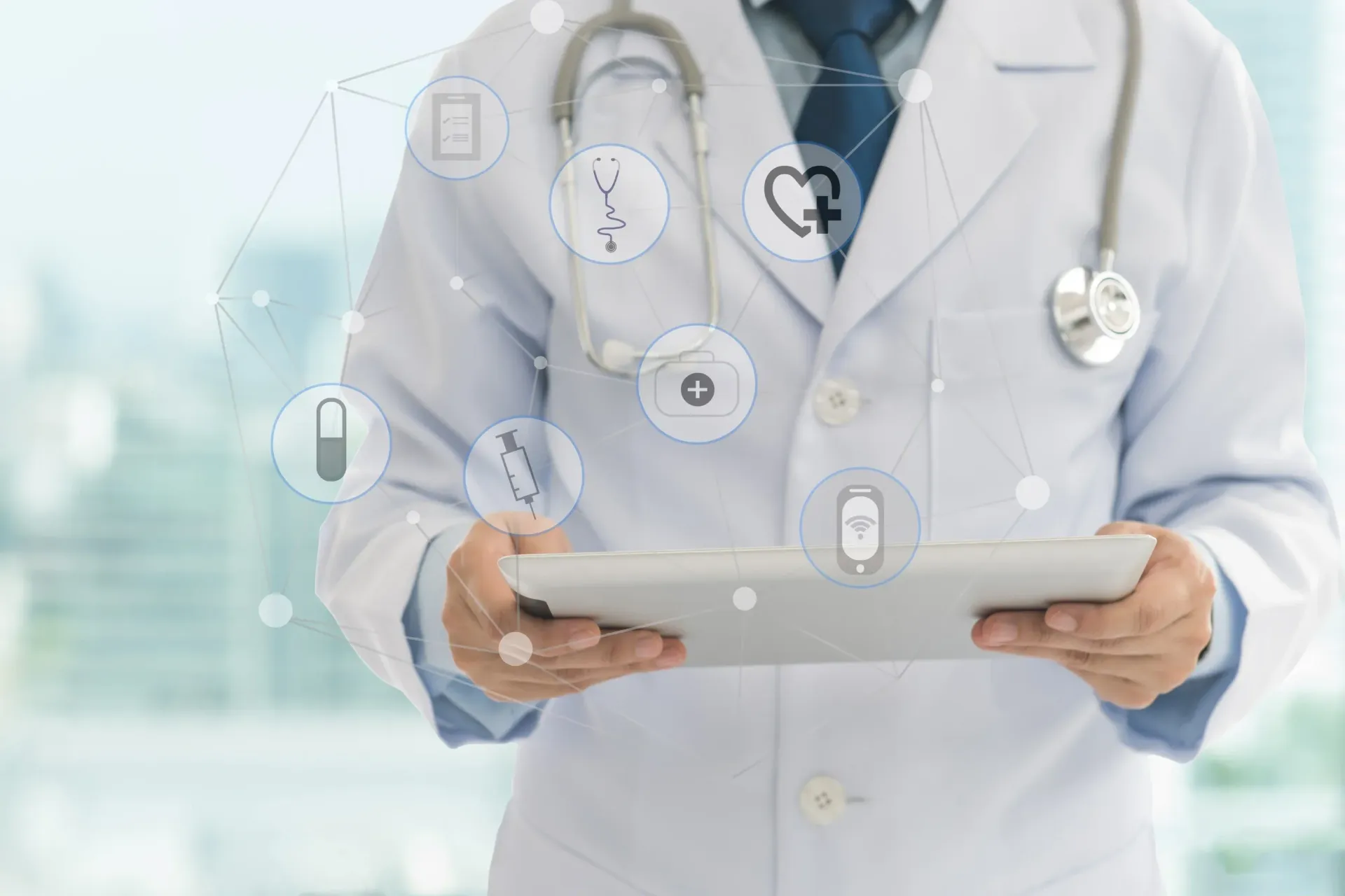 A doctor is using a laptop computer with a stethoscope around his neck.