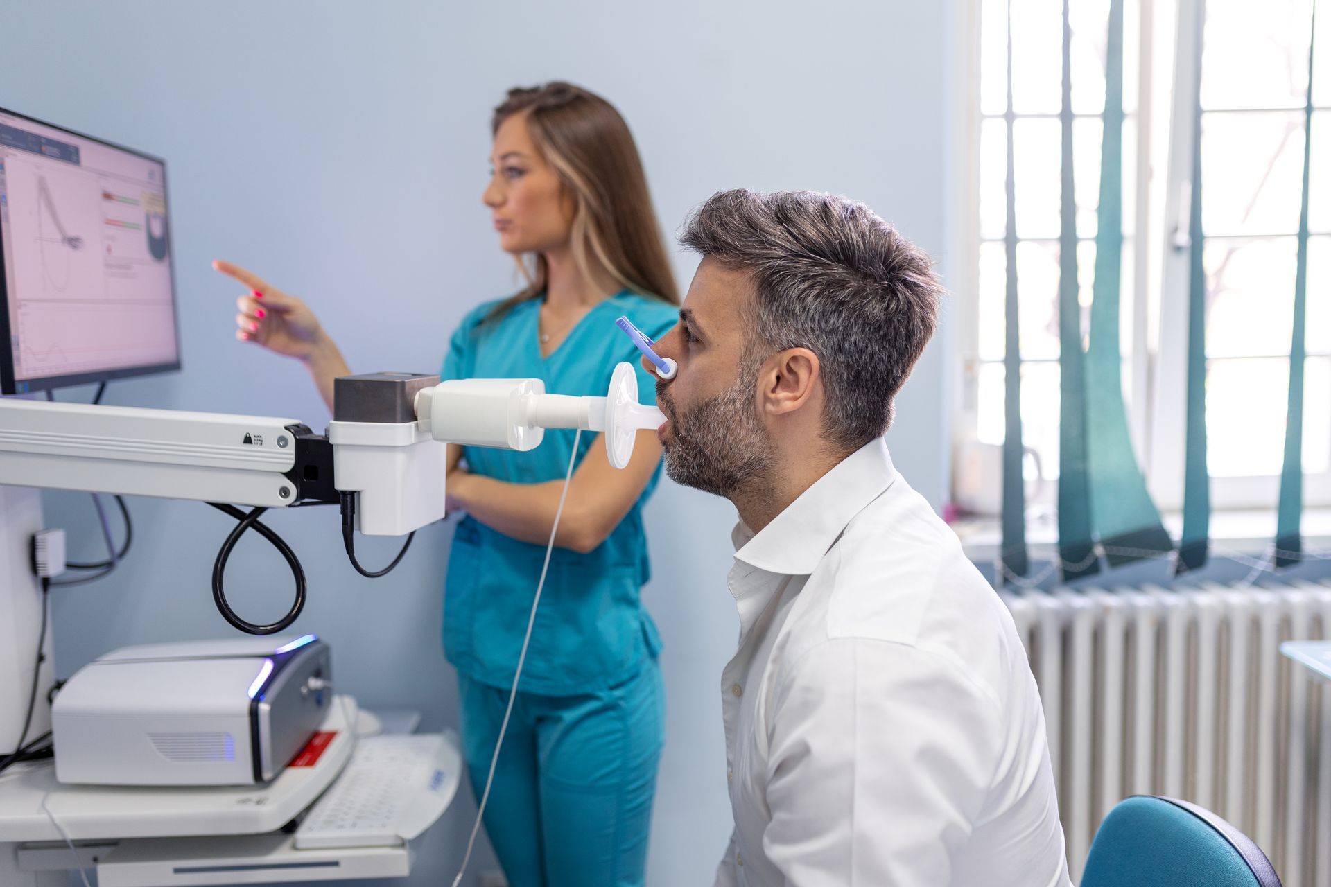 An allergist uses allergy EHR software integrated with a spirometry device to assess a patient for allergic asthma.