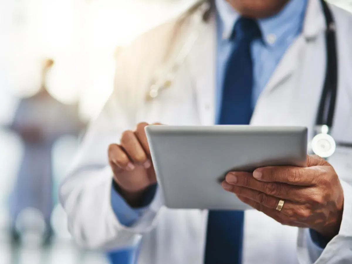 A nurse wearing a headset is sitting in front of a computer.