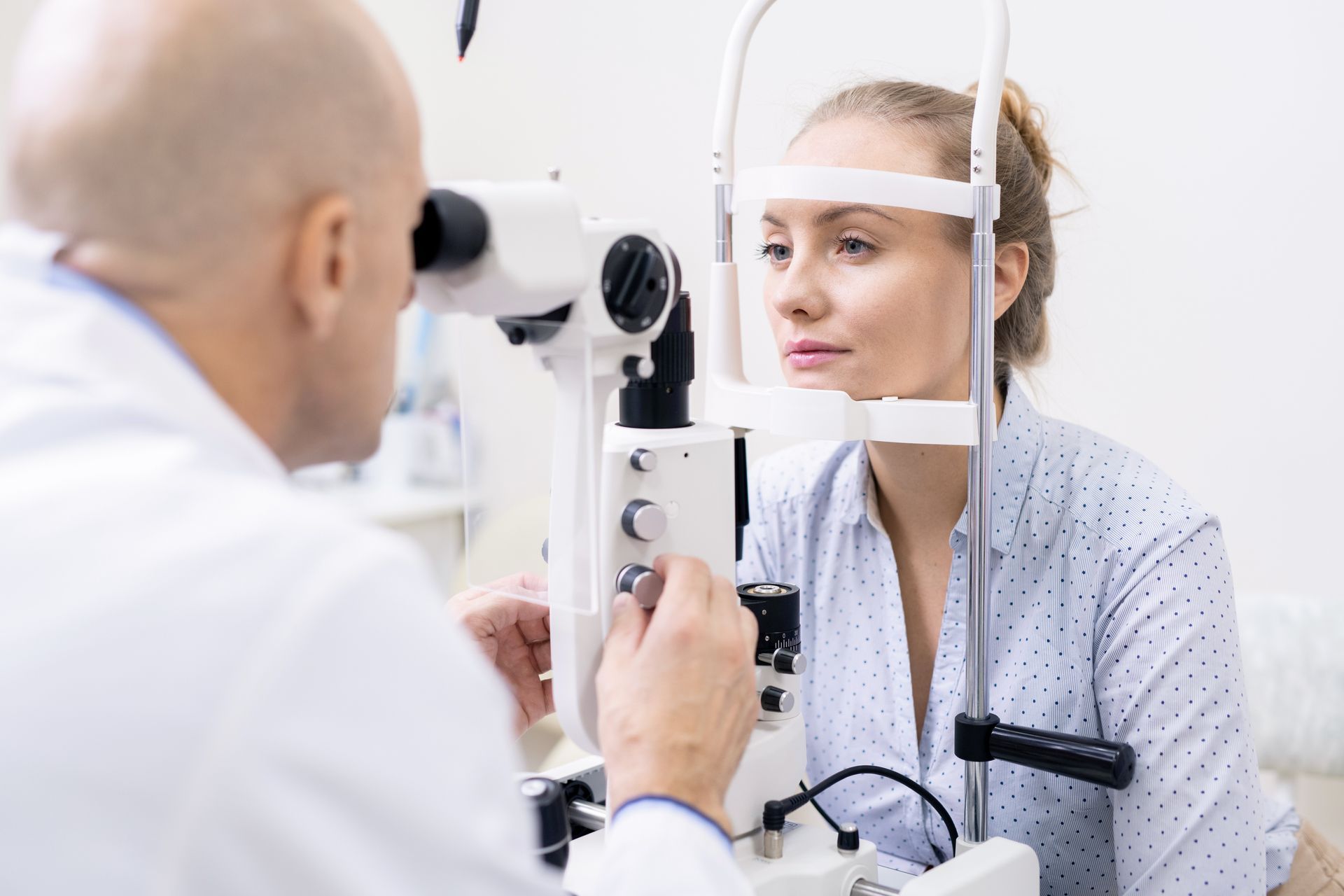 A woman is getting her eyes examined by an ophthalmologist.