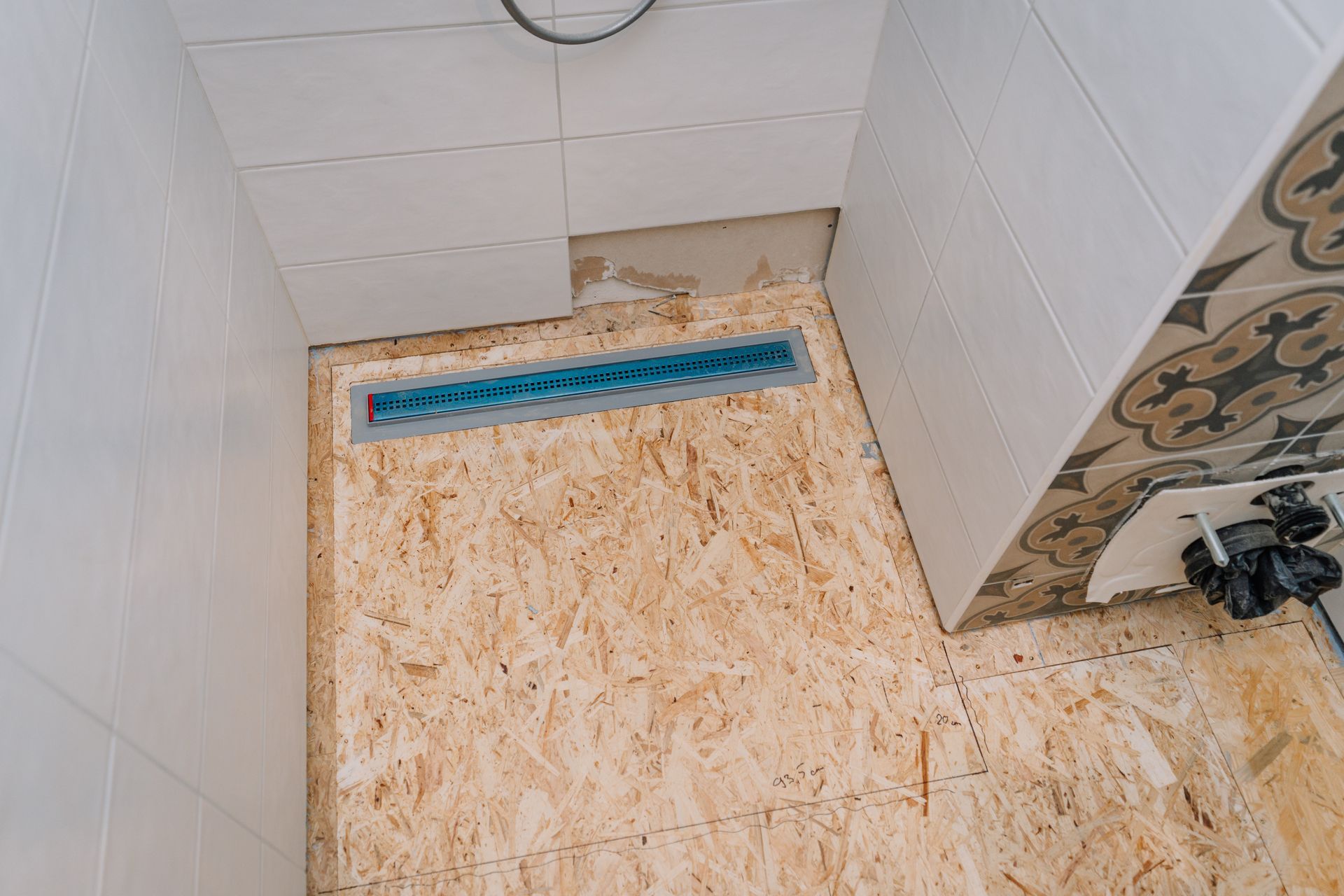 Bathroom floor lifted for pier & beam foundation repair showing exposed plywood subfloor panels.