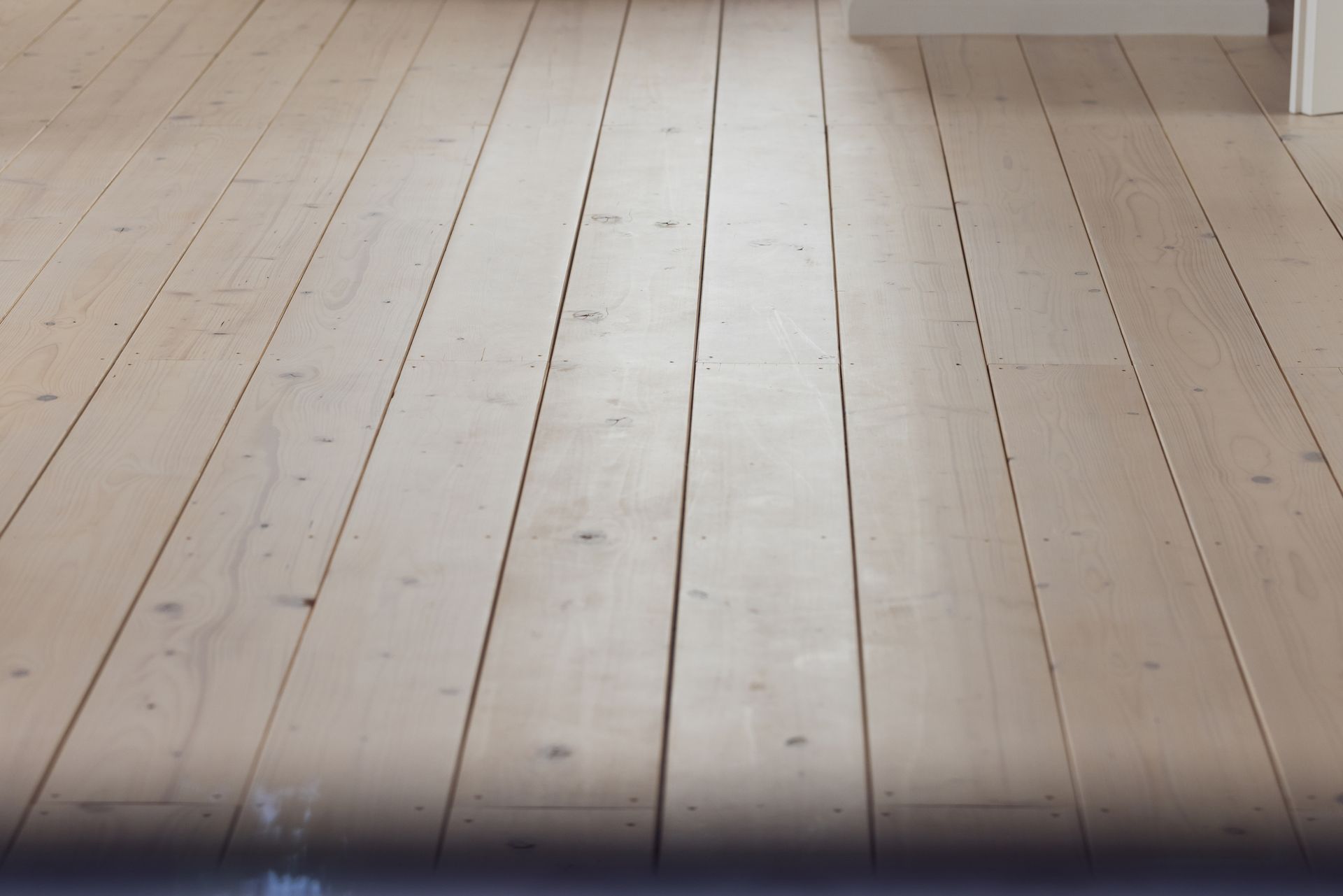 Man crawls into small brick opening, holding a flashlight and tools. Green grass surrounds the entrance.